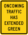 Oncoming traffic has extended green road sign (MUTCD W25-1)