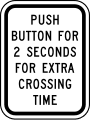 Push button for 2 seconds for extra crossing time road sign (MUTCD R10-32P)