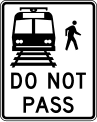 Do not pass stopped trains road sign (MUTCD R15-5)